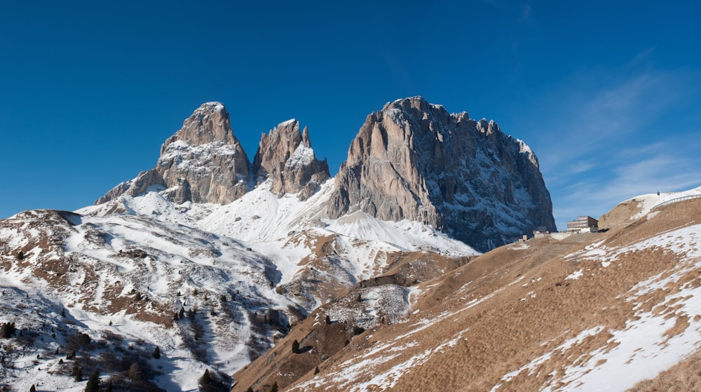 a group of mountains covered in snow under a blue sky