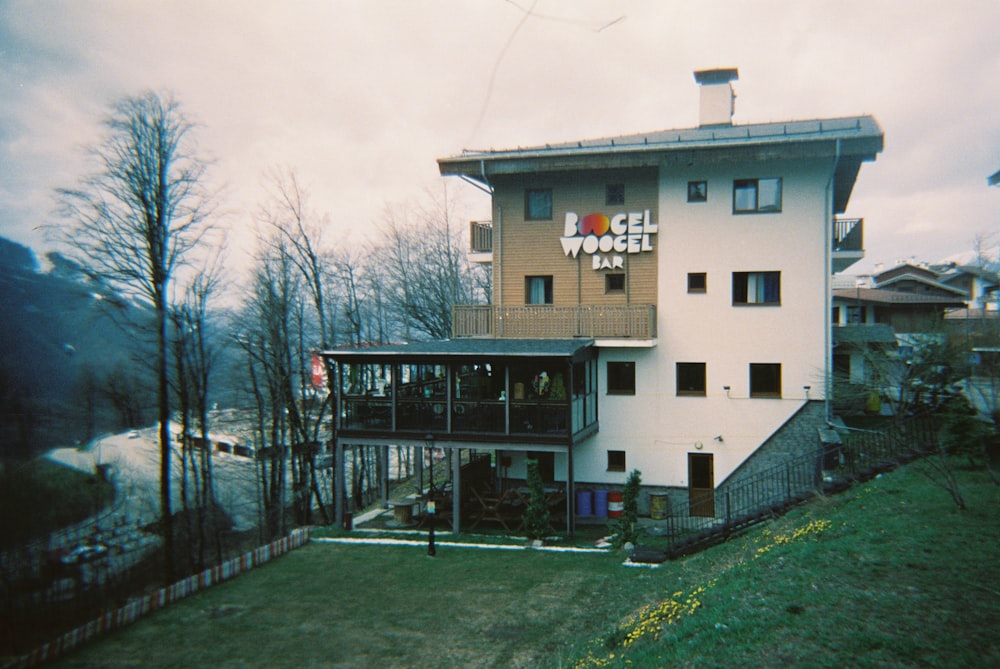 a large white building sitting on top of a lush green hillside