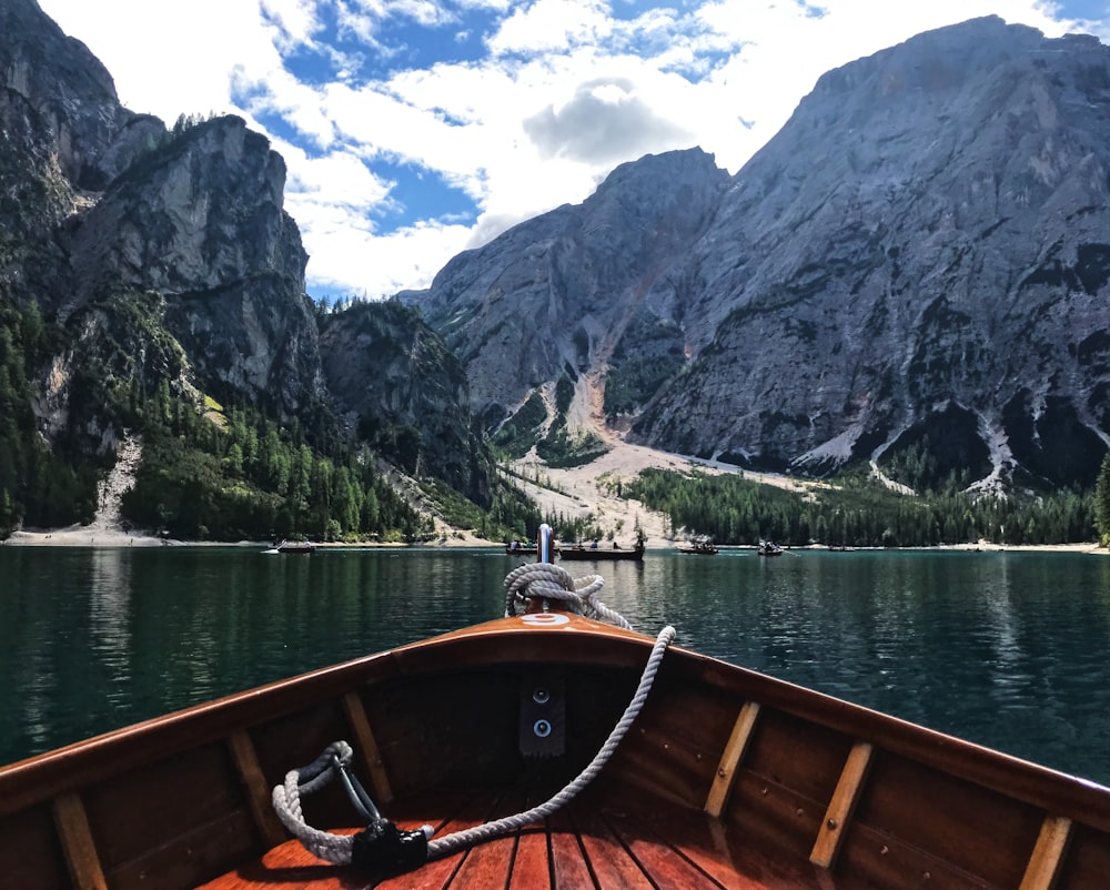 the bow of a boat on a lake with mountains in the background
