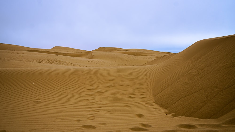 una persona caminando a través de un gran campo de arena