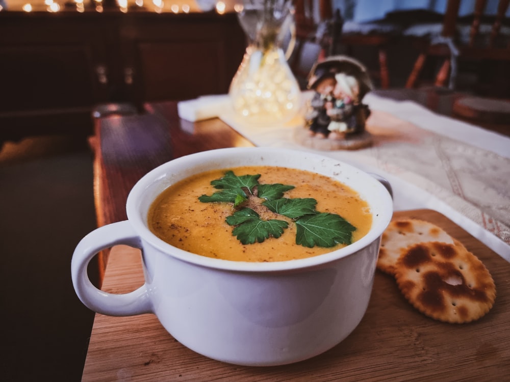 a bowl of soup on a table with crackers