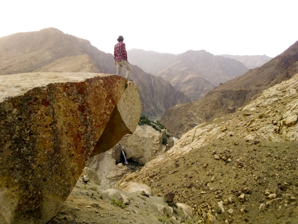 a man standing on top of a large rock