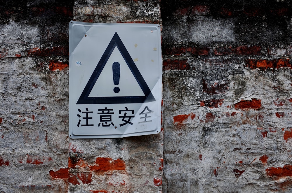 a street sign on a brick wall in an asian language