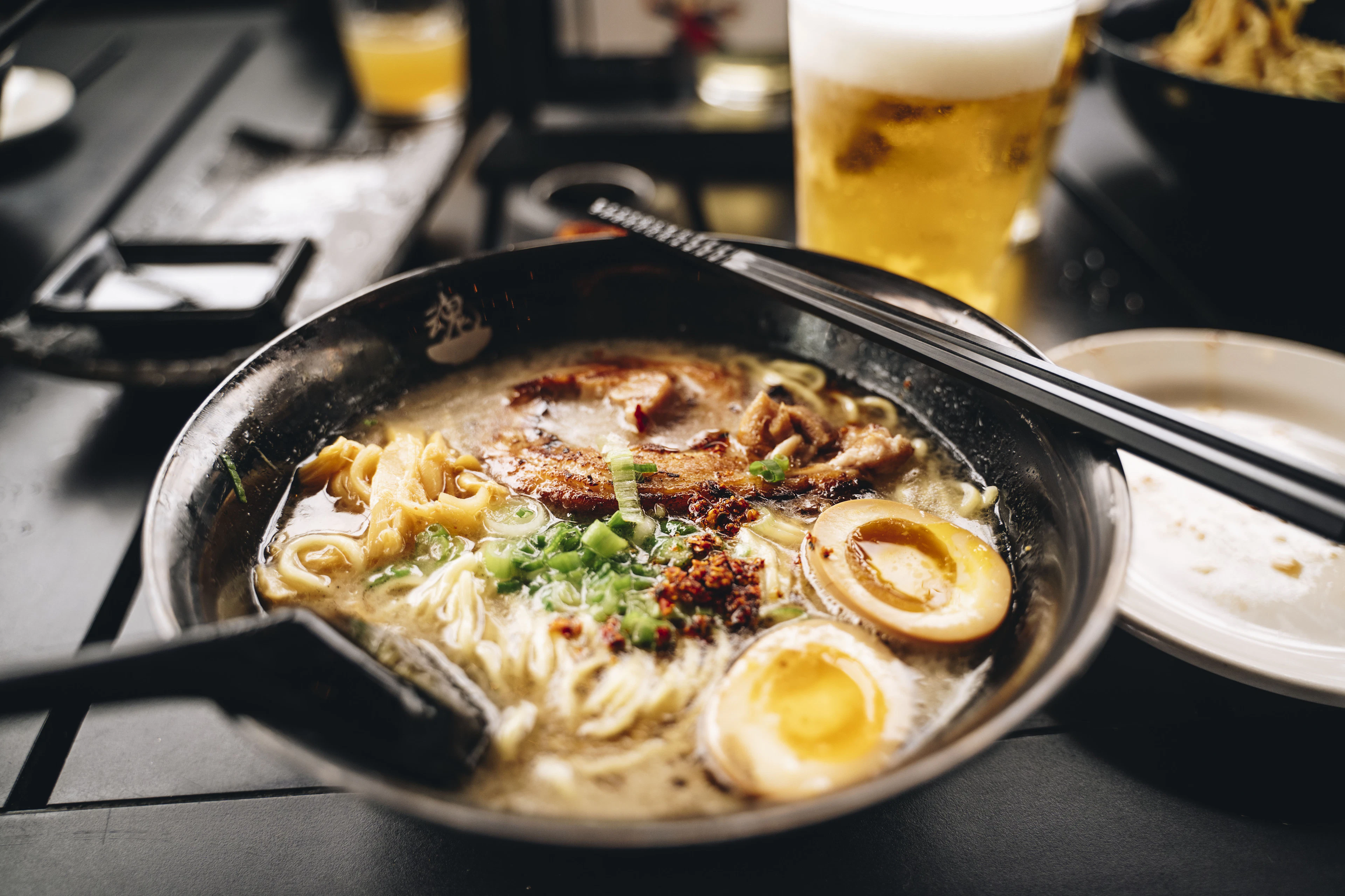 Ramen and beer on a dark izakaya counter