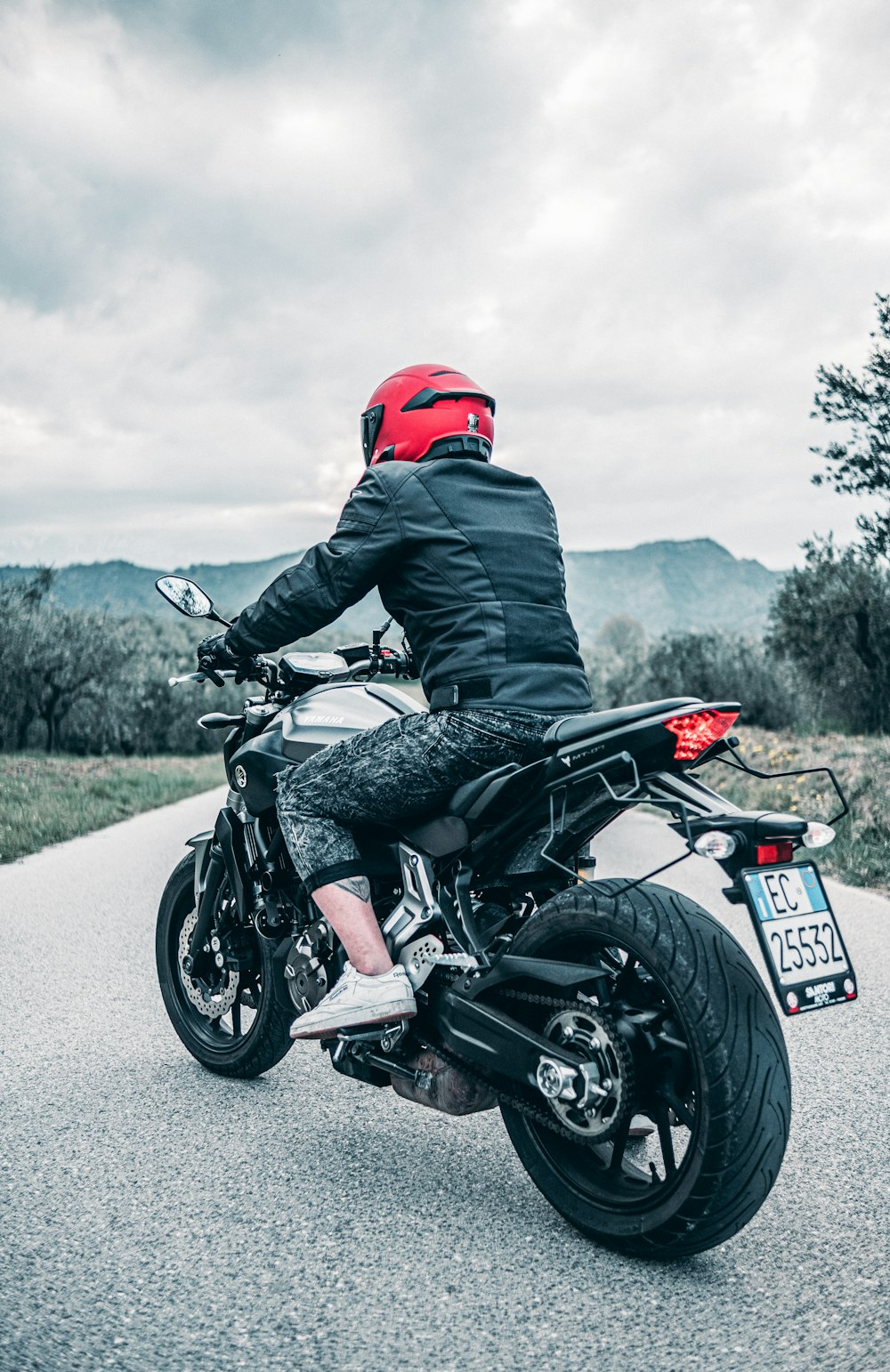 a man riding a motorcycle down a dirt road