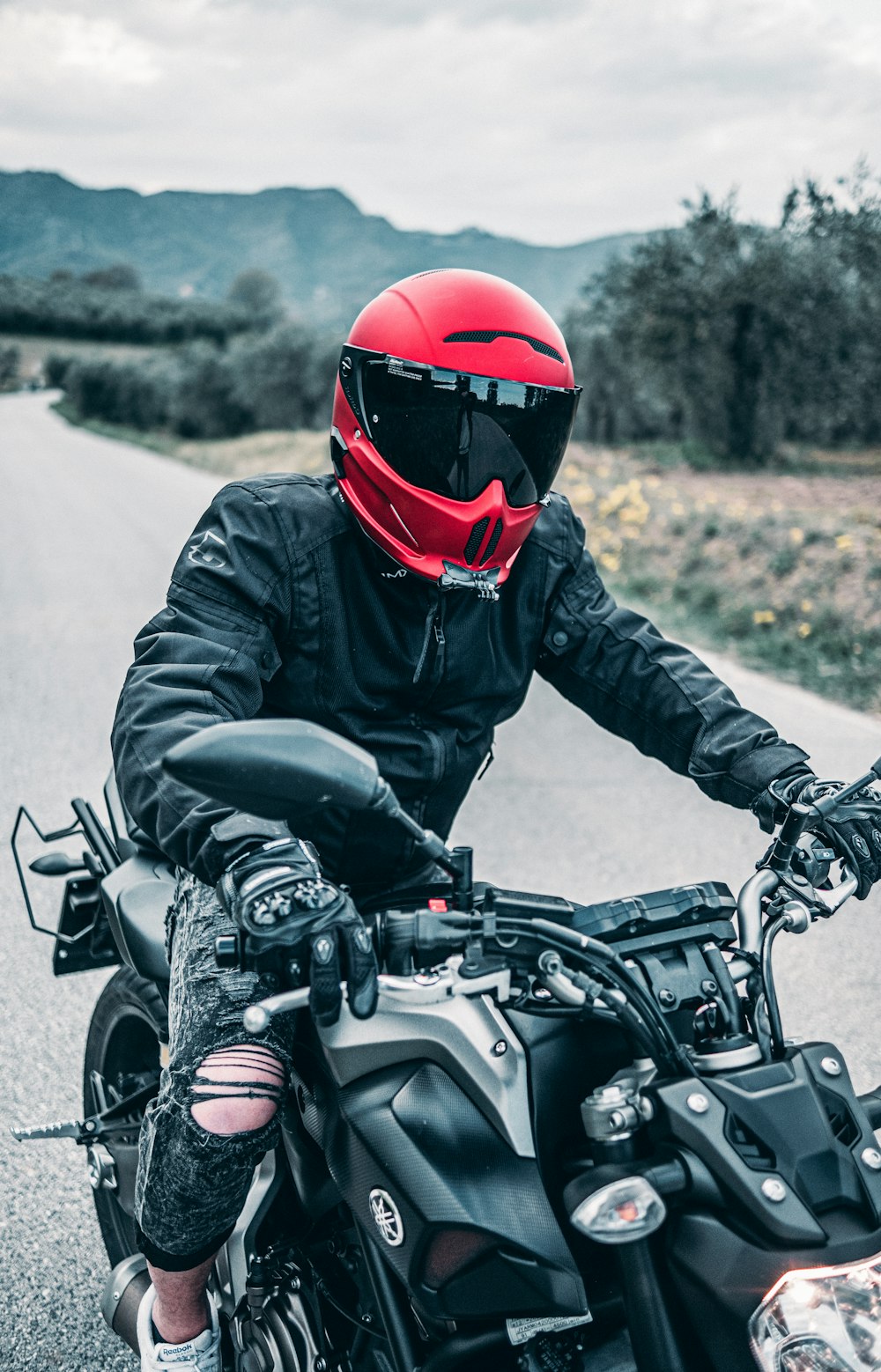 a man riding a motorcycle down a country road