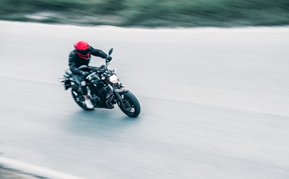 Un uomo che guida una moto lungo una strada