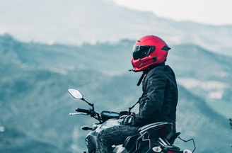 a man riding a motorcycle with a mountain in the background