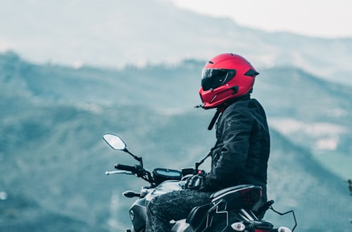 Man seated on bike wearing full face red helmet