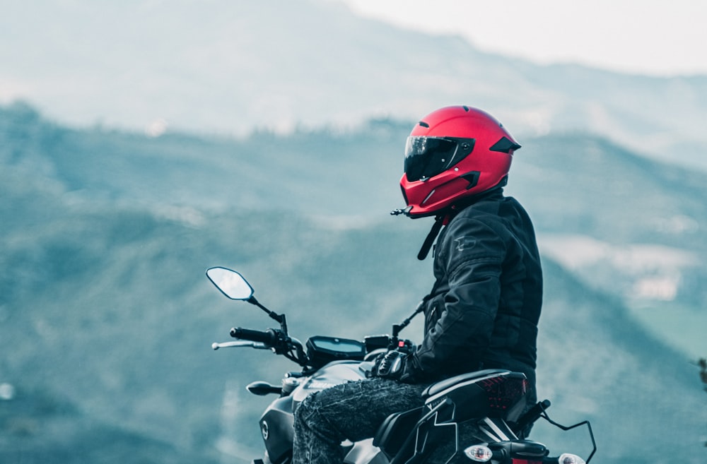 um homem que monta uma motocicleta com uma montanha no fundo