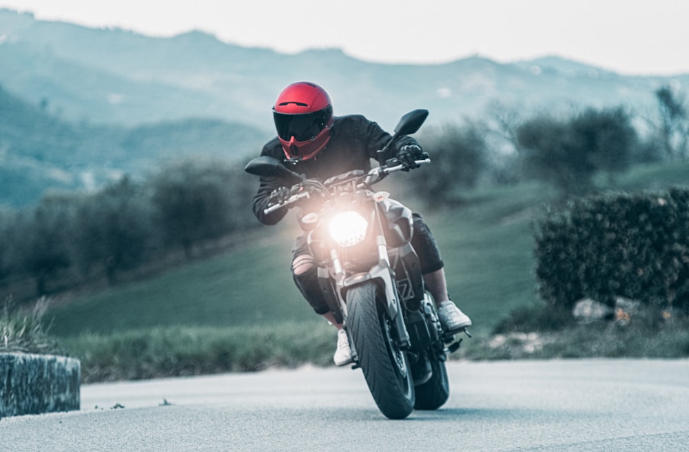 a man riding a motorcycle with a mountain in the background