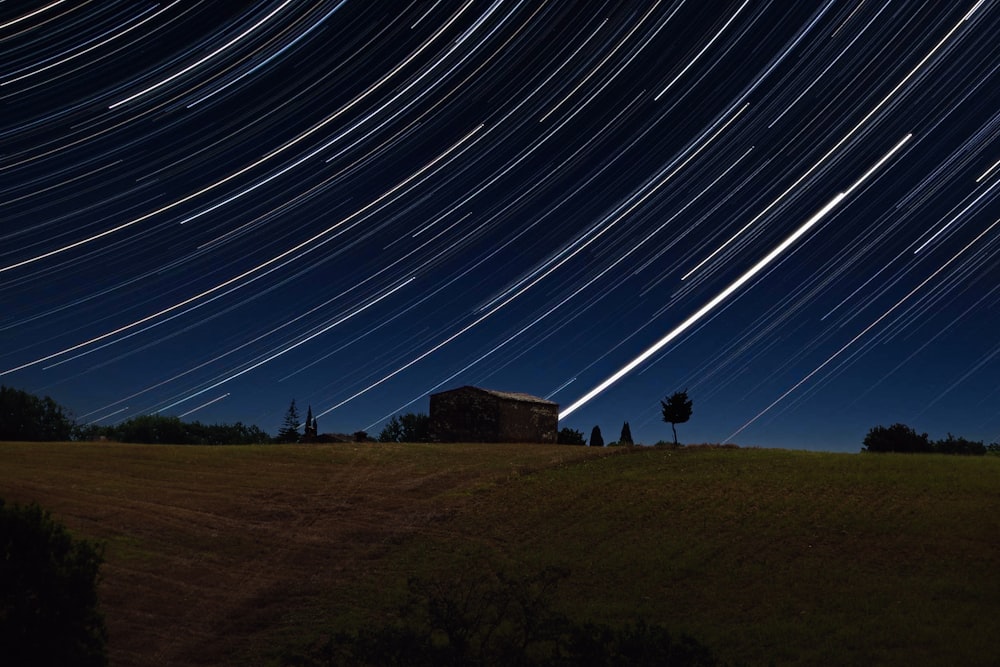 Der Nachthimmel mit einer Sternspur über einem Feld