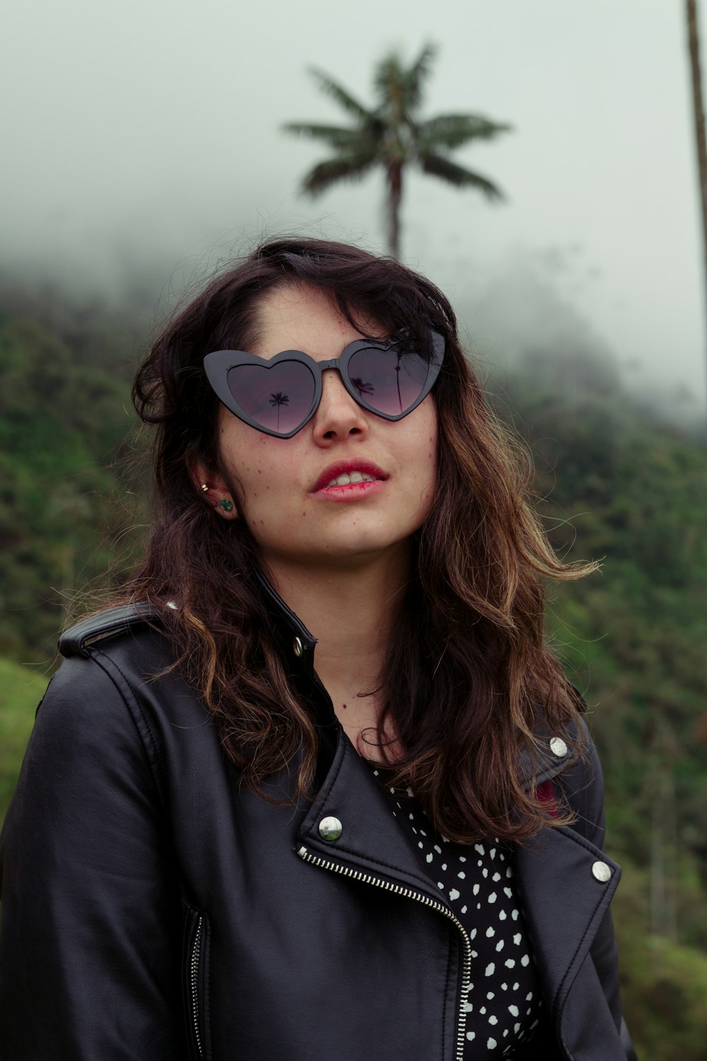 a woman wearing a black jacket and sunglasses