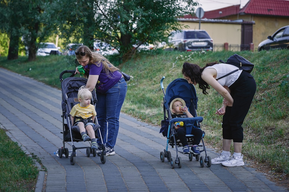 a woman pushing a stroller with two children in it