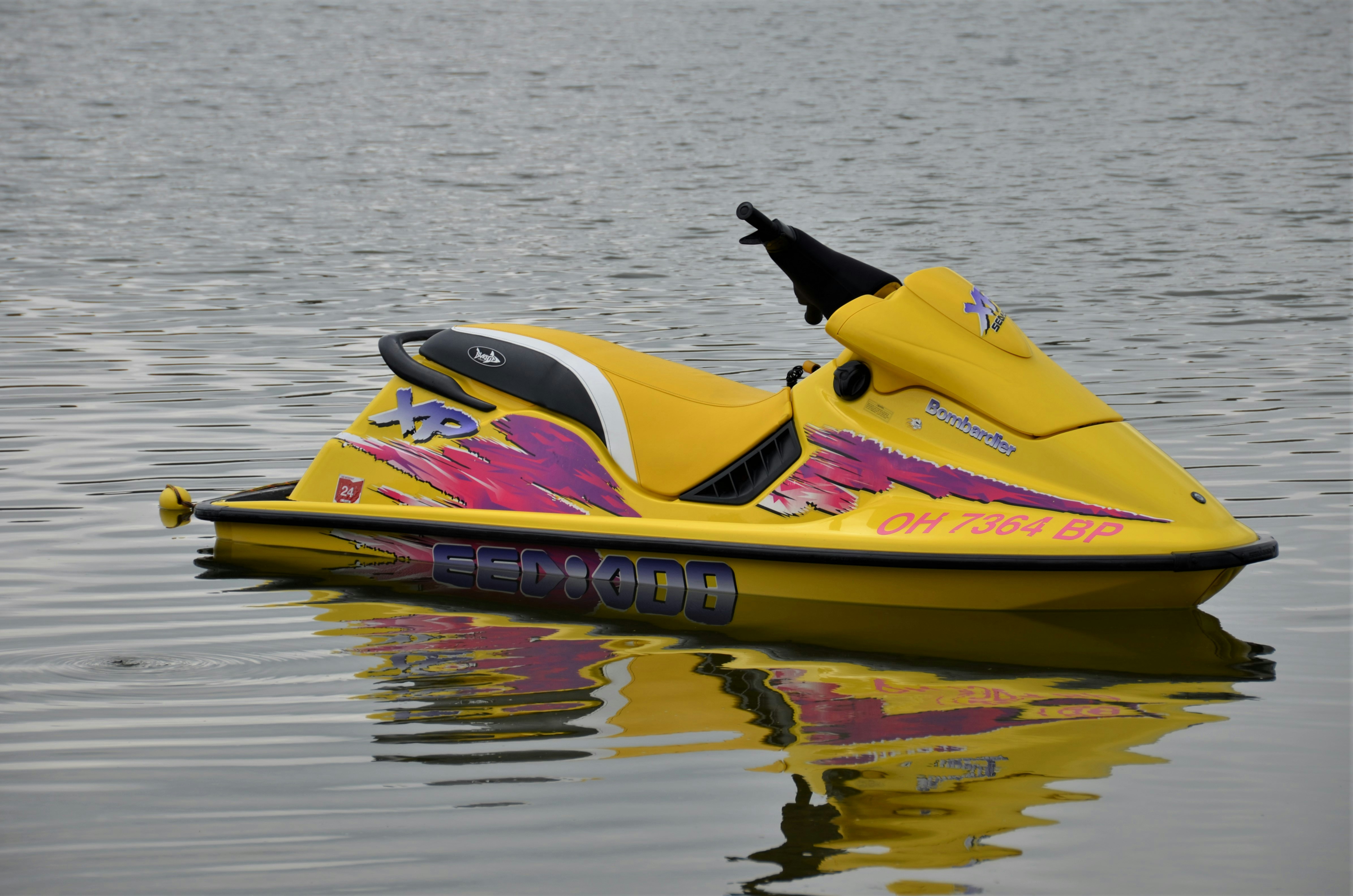 a yellow and purple jet ski is in the water