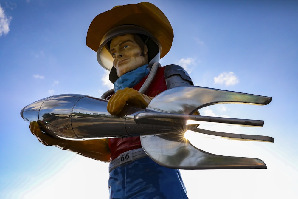 a statue of a man holding a giant fork