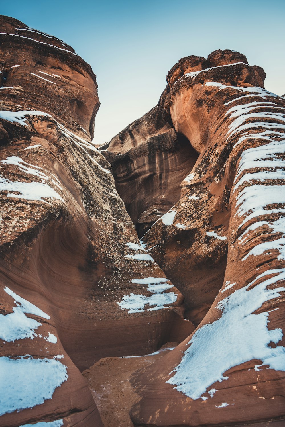 a large rock formation with snow on the ground