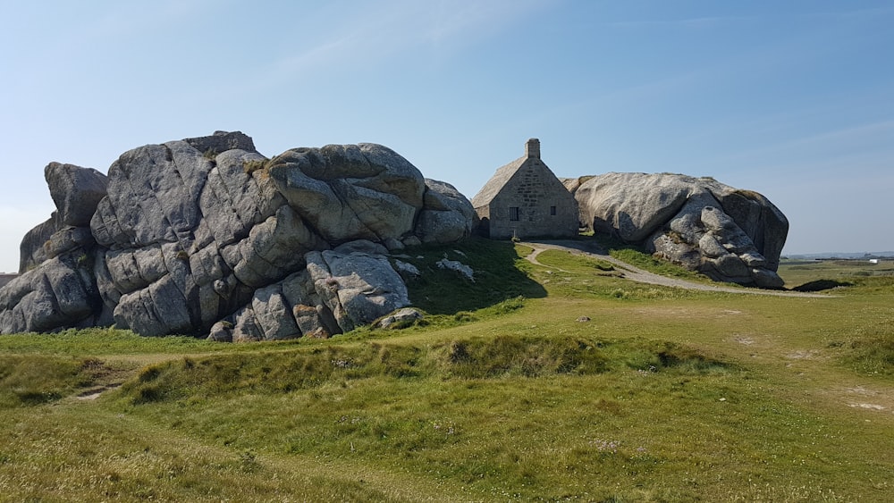 gray rock formation on green grass field during daytime