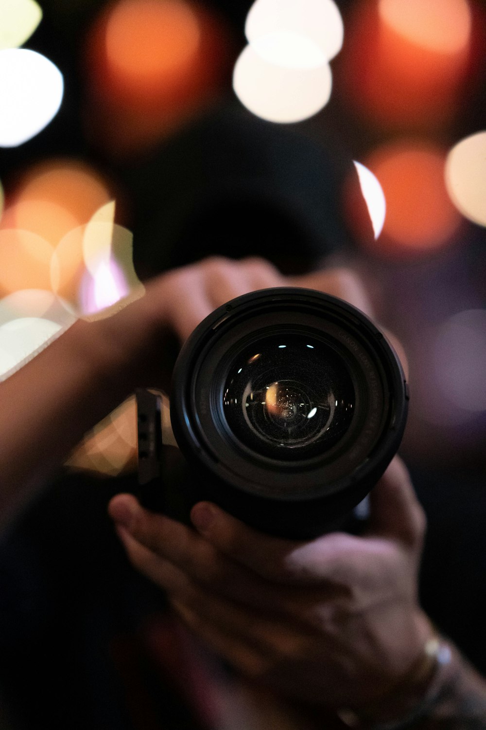 person holding black camera lens