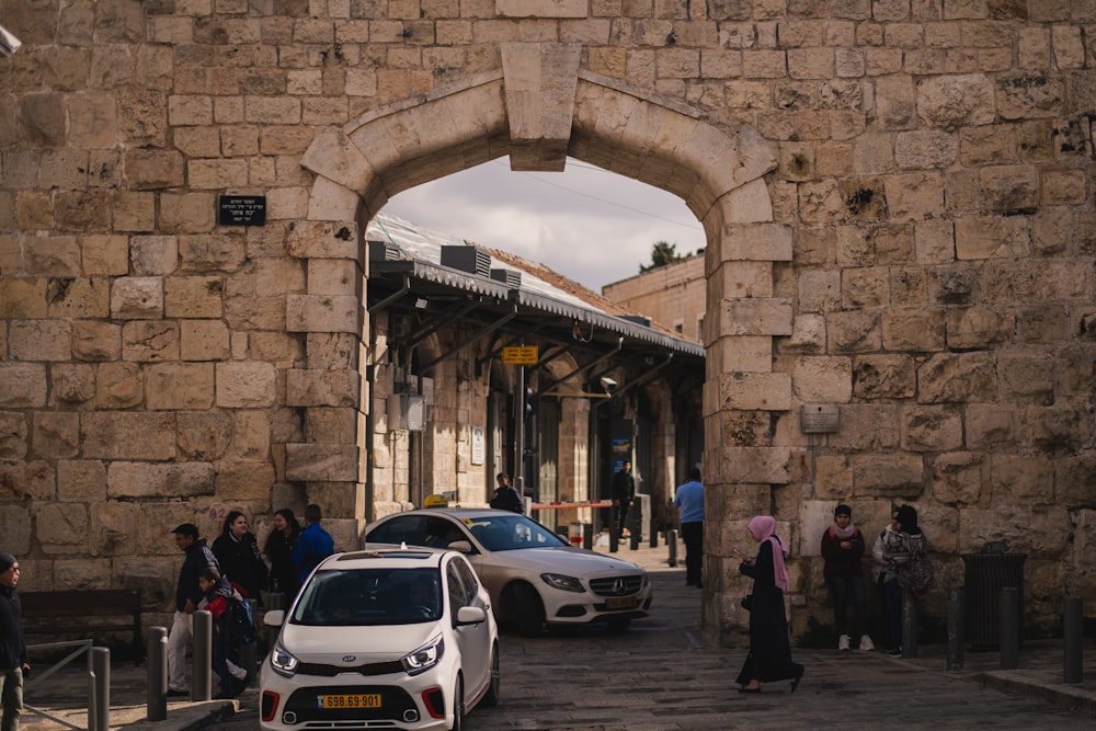 a group of cars parked in front of a stone wall