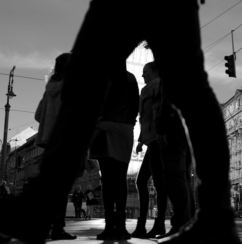 a group of people standing on a street next to a traffic light