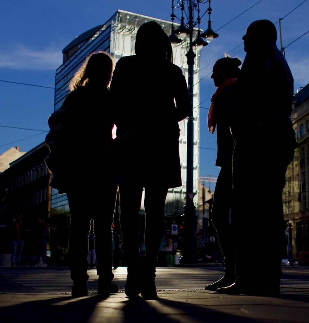 um grupo de pessoas em pé em uma rua da cidade