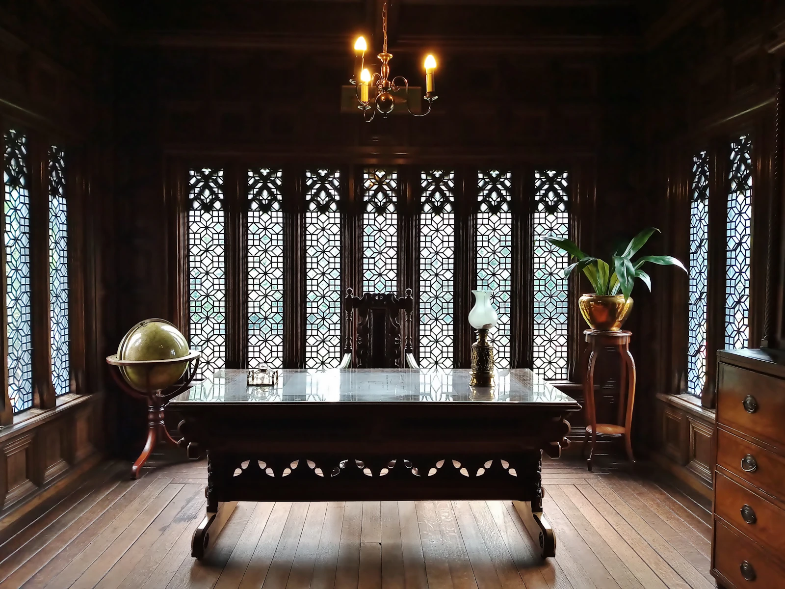 A heritage British study — wooden table, wooden door, the kind of room where rare objects are kept
