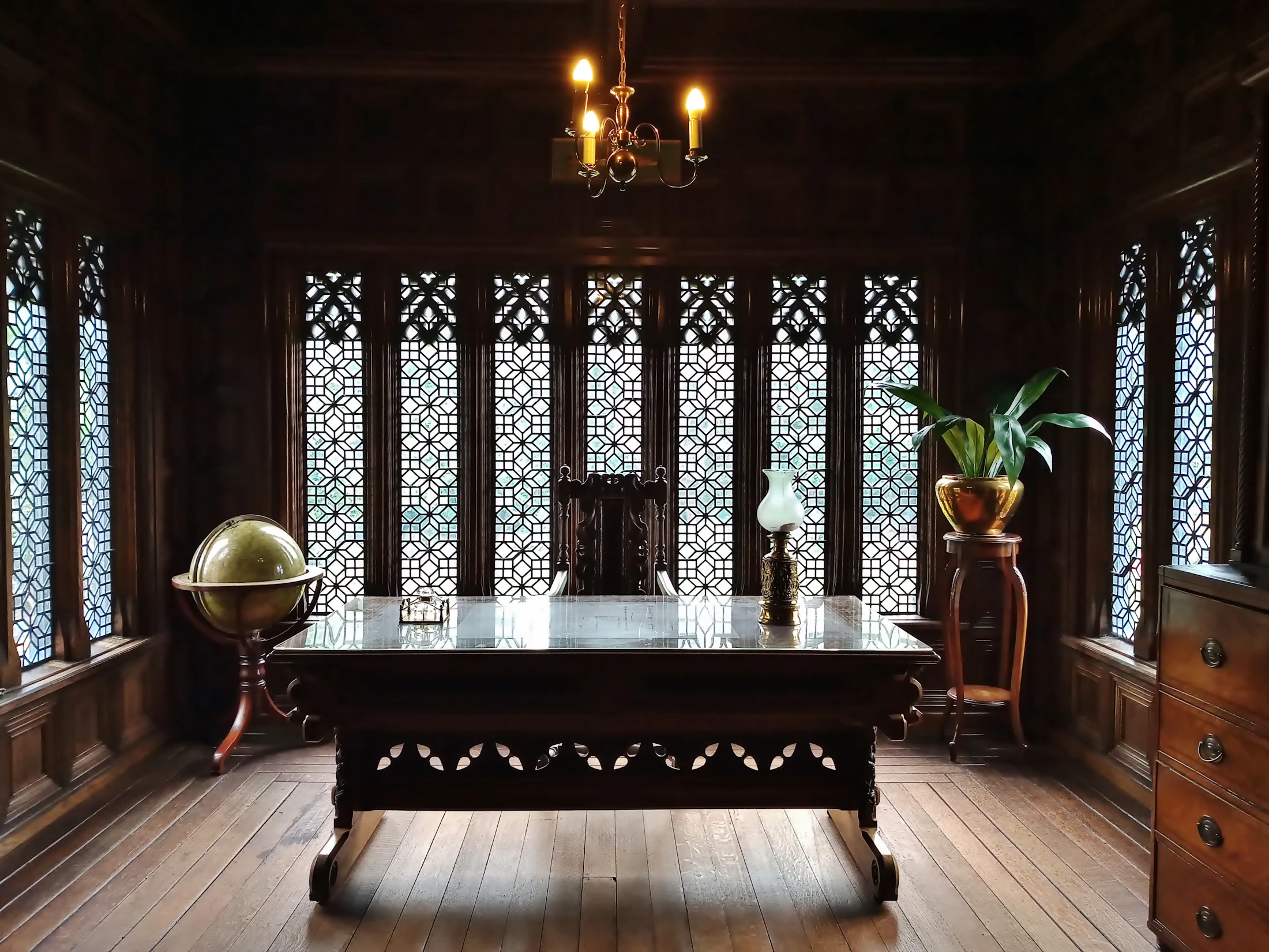 A heritage British study — wooden table, wooden door, the kind of room where rare objects are kept