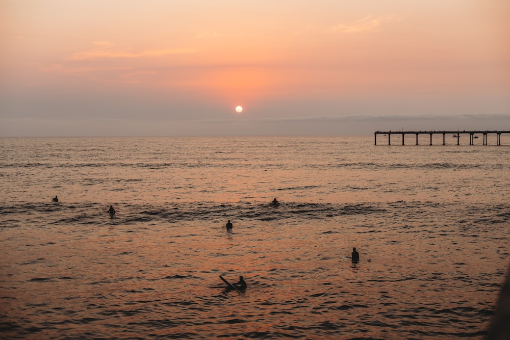 silhouette of people on beach during sunset