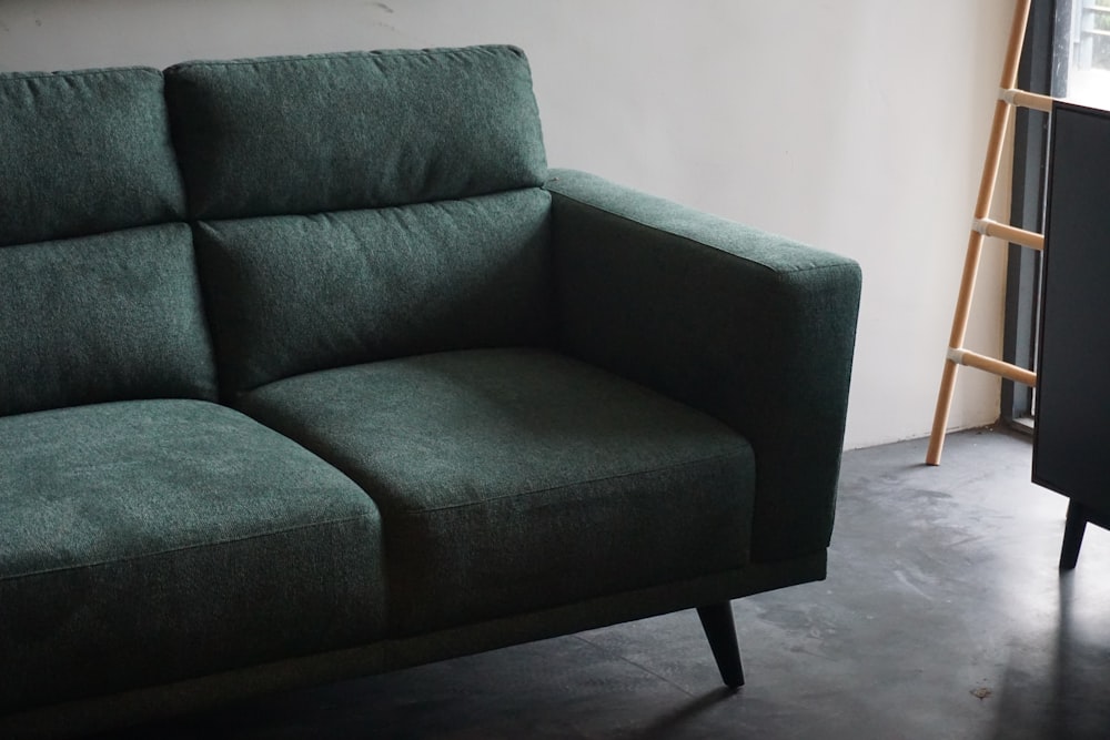 gray cushion armchair beside white wall