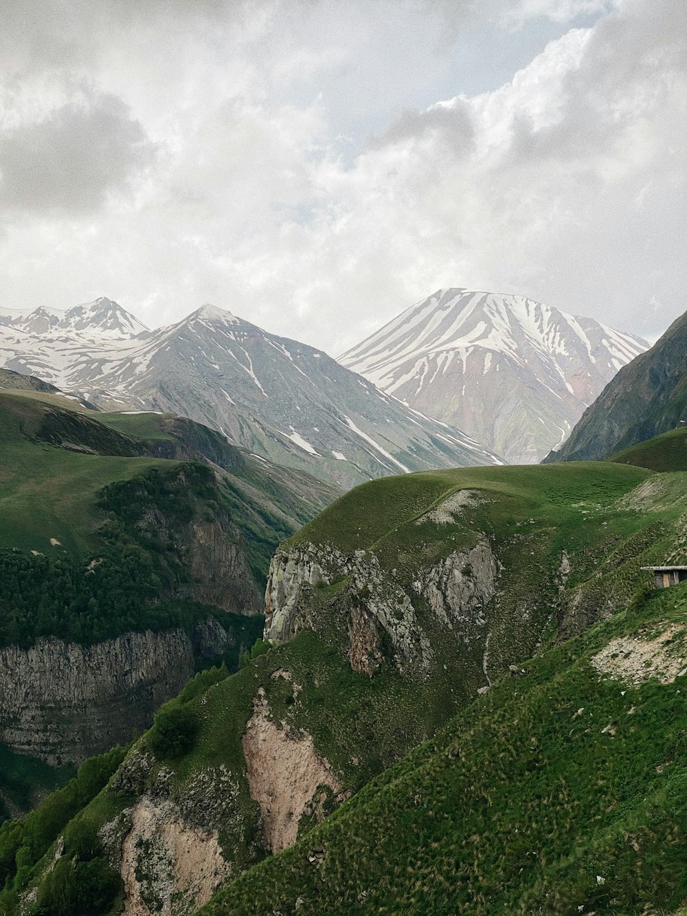 montagnes vertes et blanches sous des nuages blancs pendant la journée