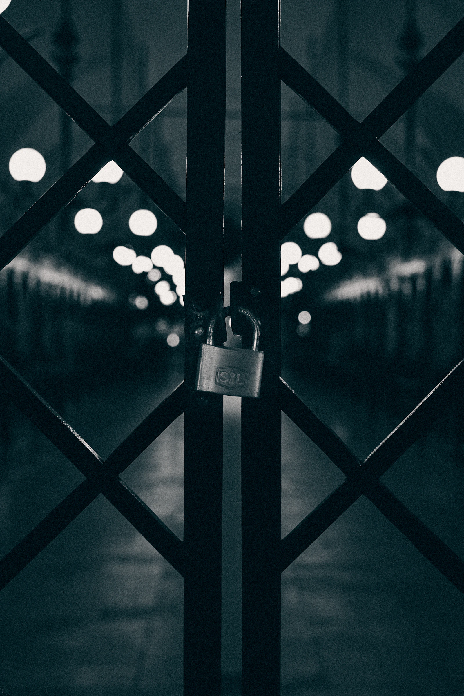 Gray padlock on black metal fence