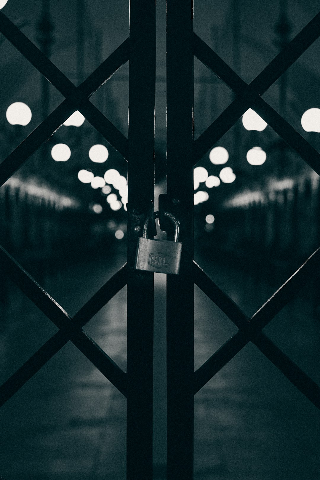  gray padlock on black metal fence lock