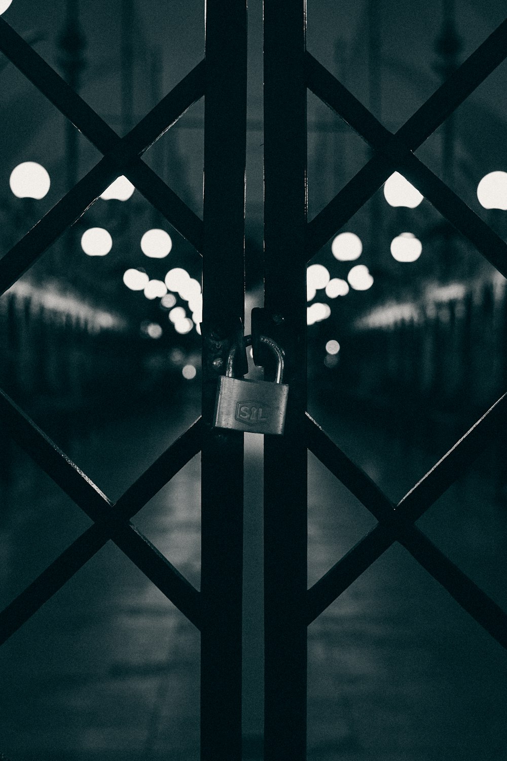 gray padlock on black metal fence