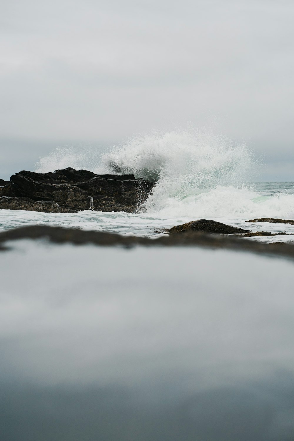 a body of water with a wave crashing over it