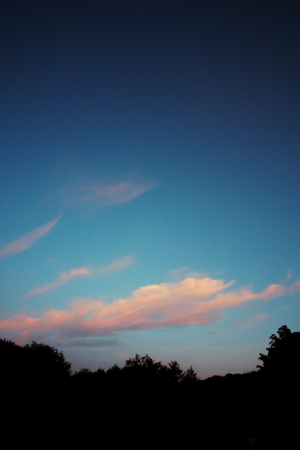 a plane flying through a blue sky with clouds