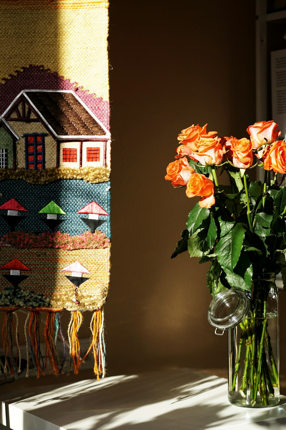 a vase filled with orange roses on top of a table