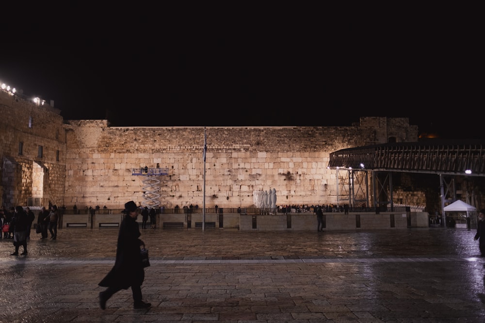 a person walking in front of a stone building