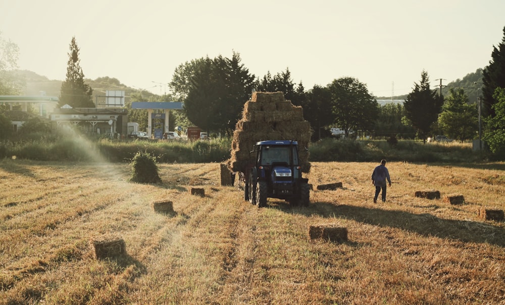 Tractor azul en campo marrón durante el día