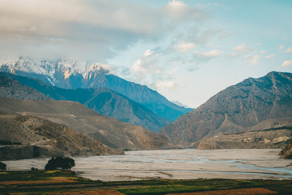 a view of a mountain range with a lake in the foreground