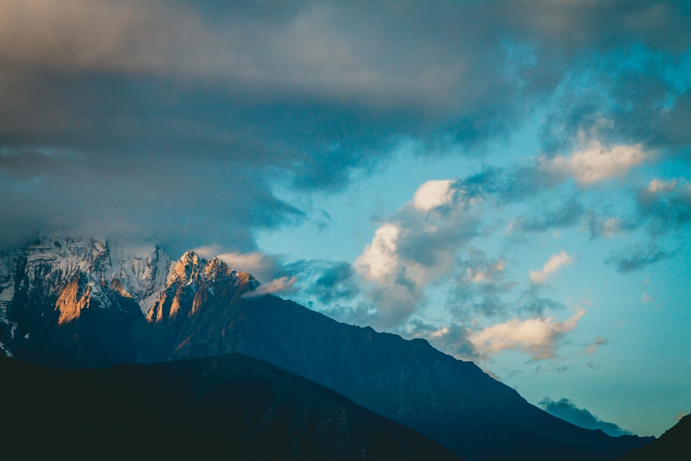 a view of a mountain range with clouds in the sky