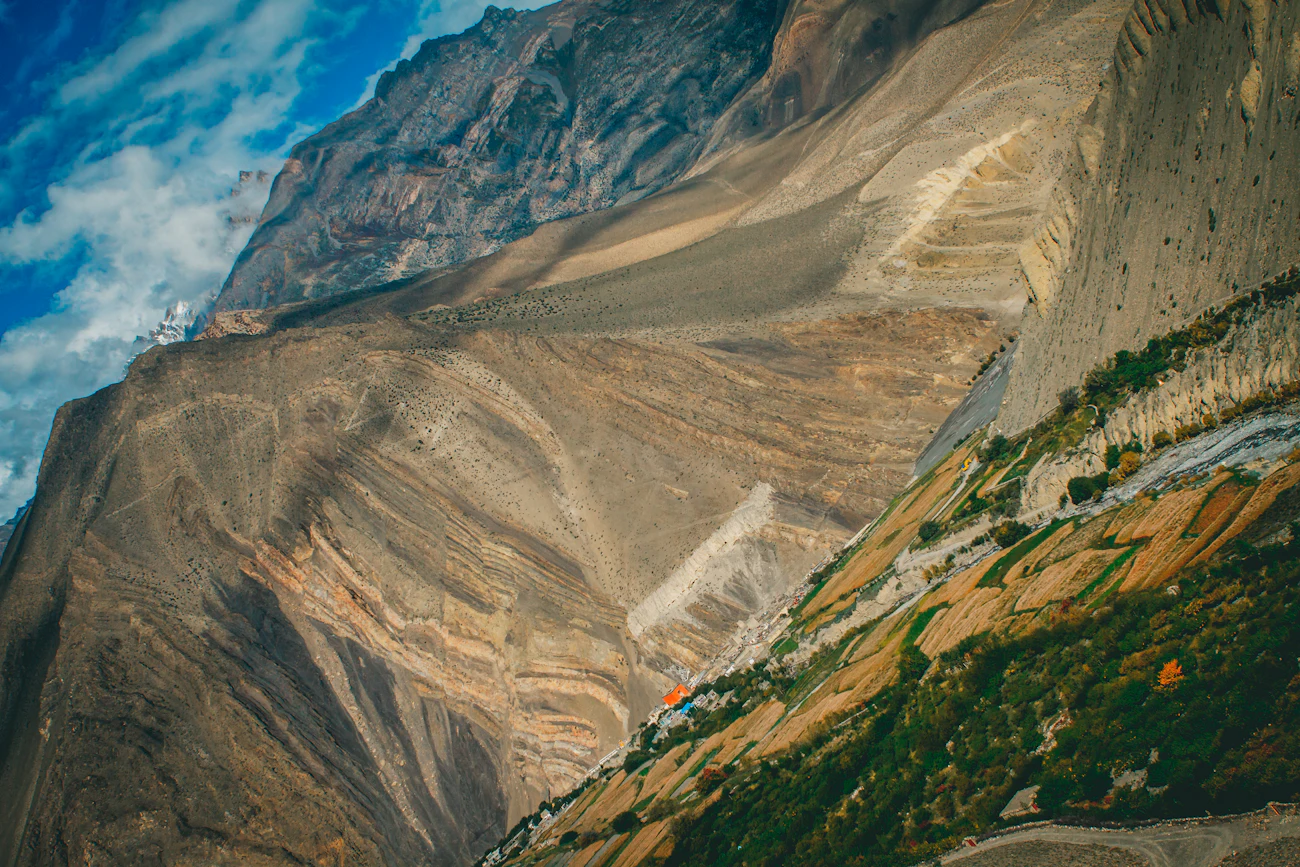 A road cutting through a Himalayan mountain valley
