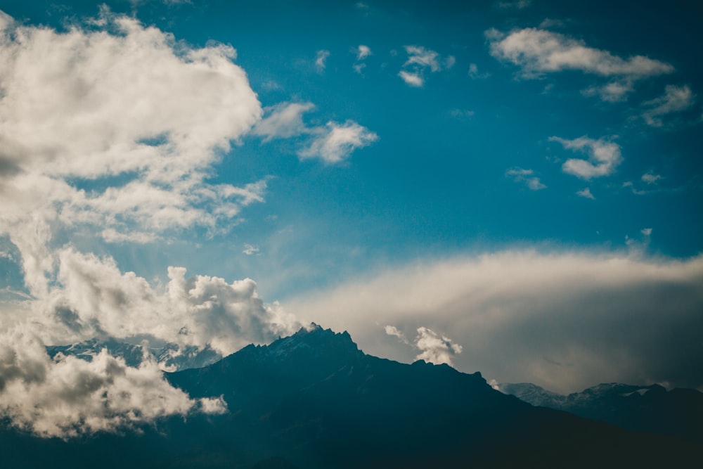 a view of a mountain with clouds in the sky