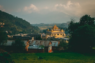 A serene Himalayan valley with ancient temples nestled among lush greenery under a golden sunset.