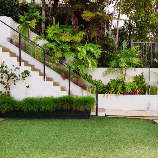 a white house with a green lawn and stairs