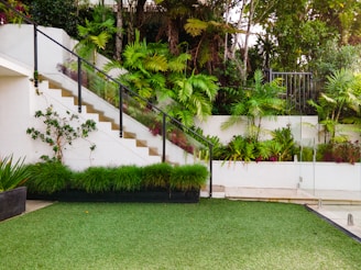 a white house with a green lawn and stairs