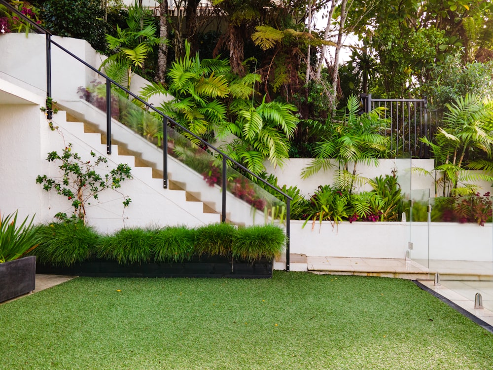 Una casa blanca con césped verde y escaleras