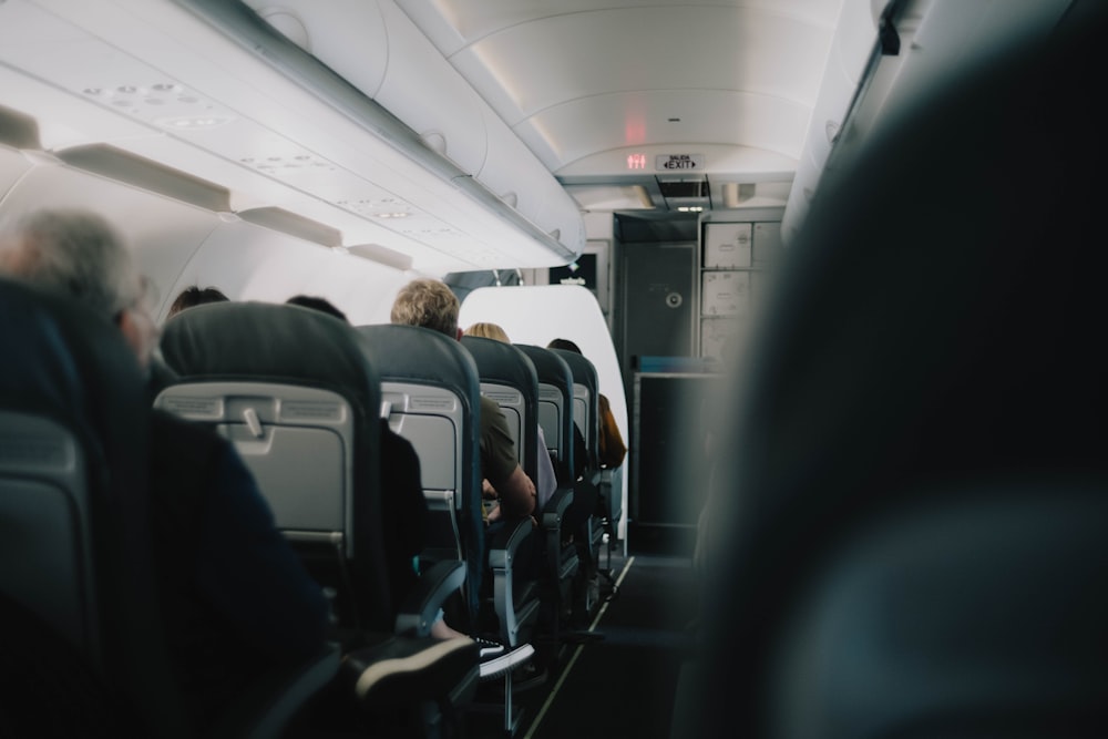 um grupo de pessoas sentadas em assentos em um avião