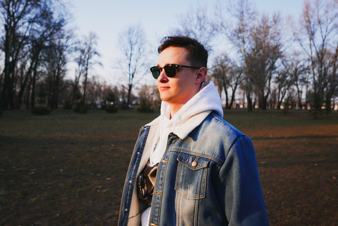 man in blue denim jacket wearing black sunglasses