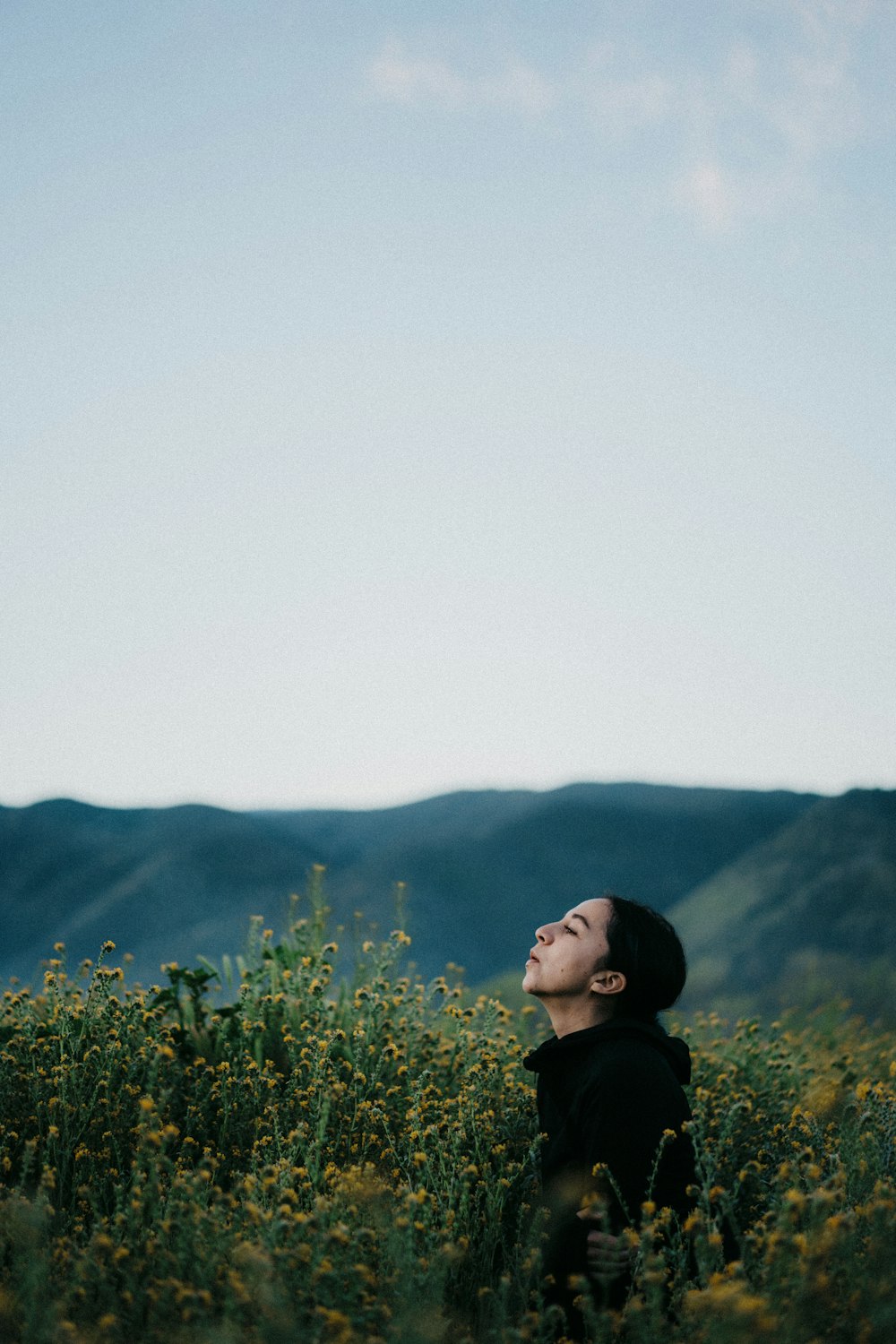 a woman standing in a field of yellow flowers